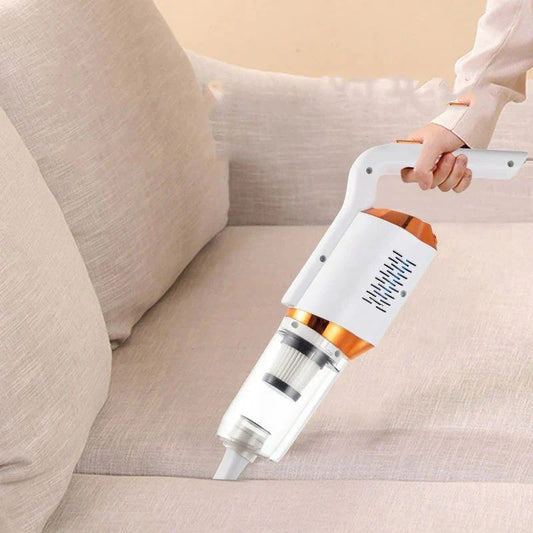 Handheld vacuum cleaner being used on a beige sofa