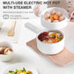 Multi-use electric hot pot with steamer on a white surface with food.